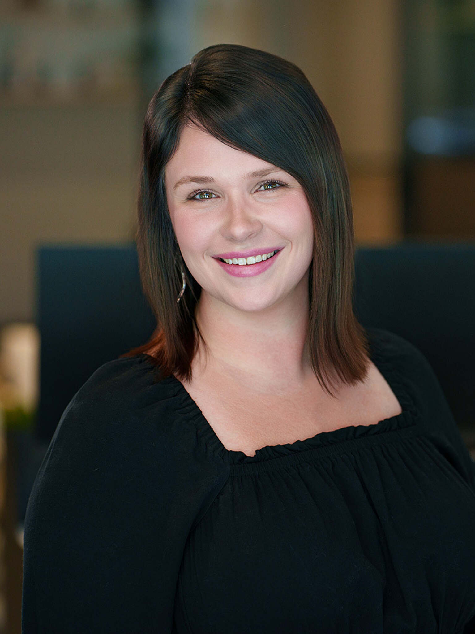 Woman with short dark hair smiling for a headshot