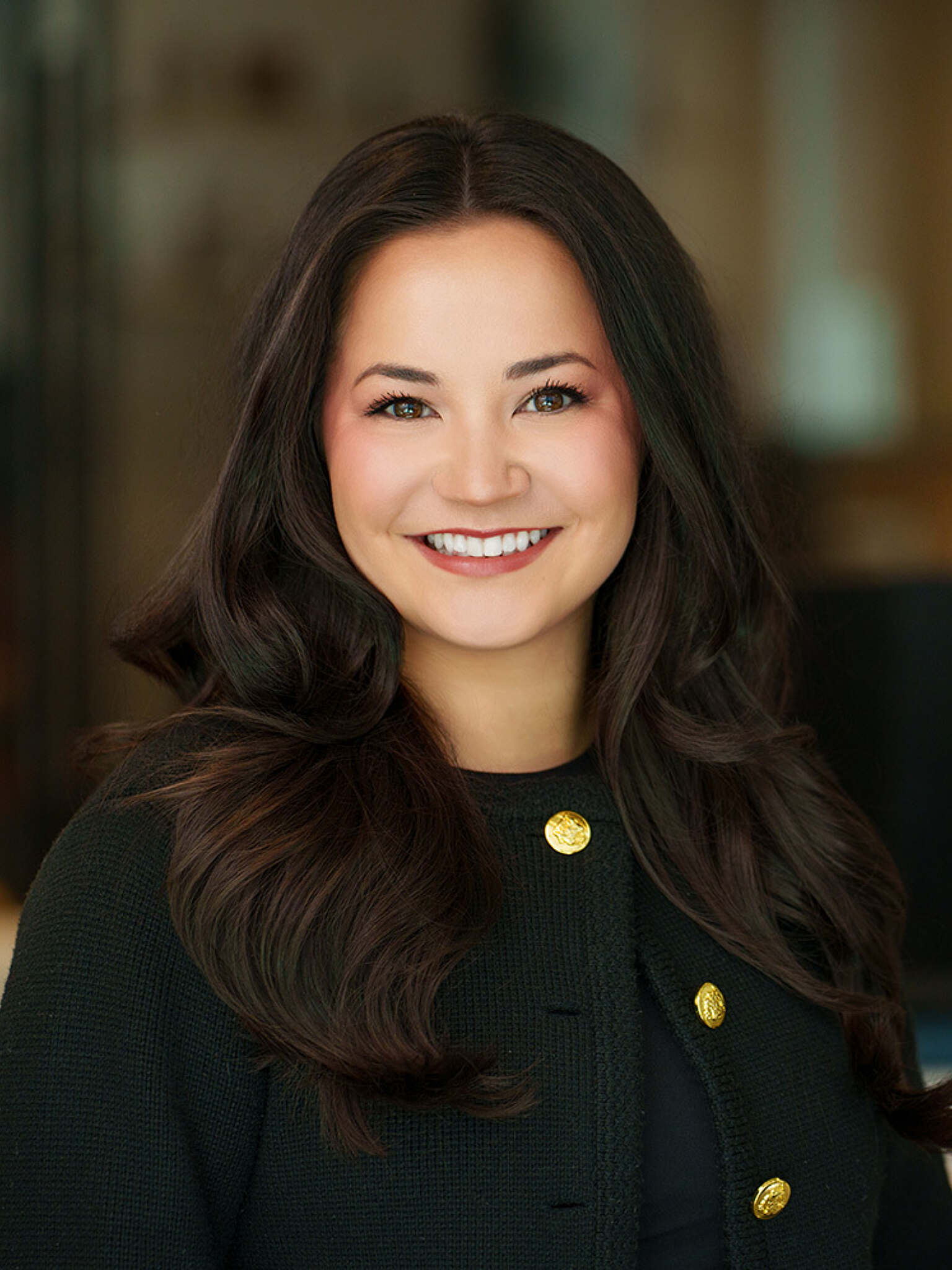 A woman with dark hair smiling for a headshot