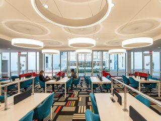 workstations with blue chairs and long white tables for collaboration