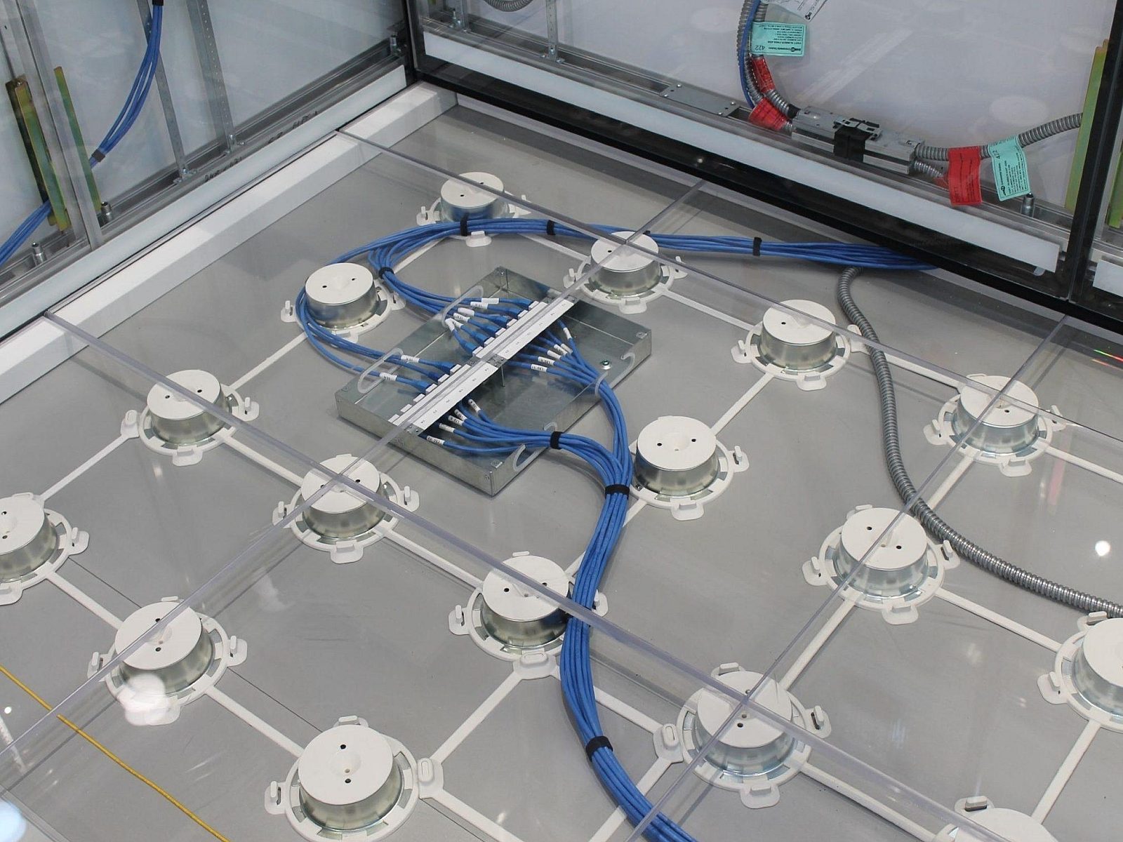 DIRTT Access Floor with see-through tiles showing the technology wiring that lives underneath the floor