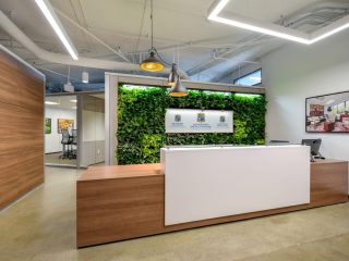 DIRTT Breathe Walls with live plants inside a wall behind an administration station in a lobby