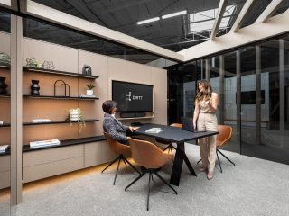 DIRTT private office space with shelves, a table, chairs, and a TV integrated into the wall
