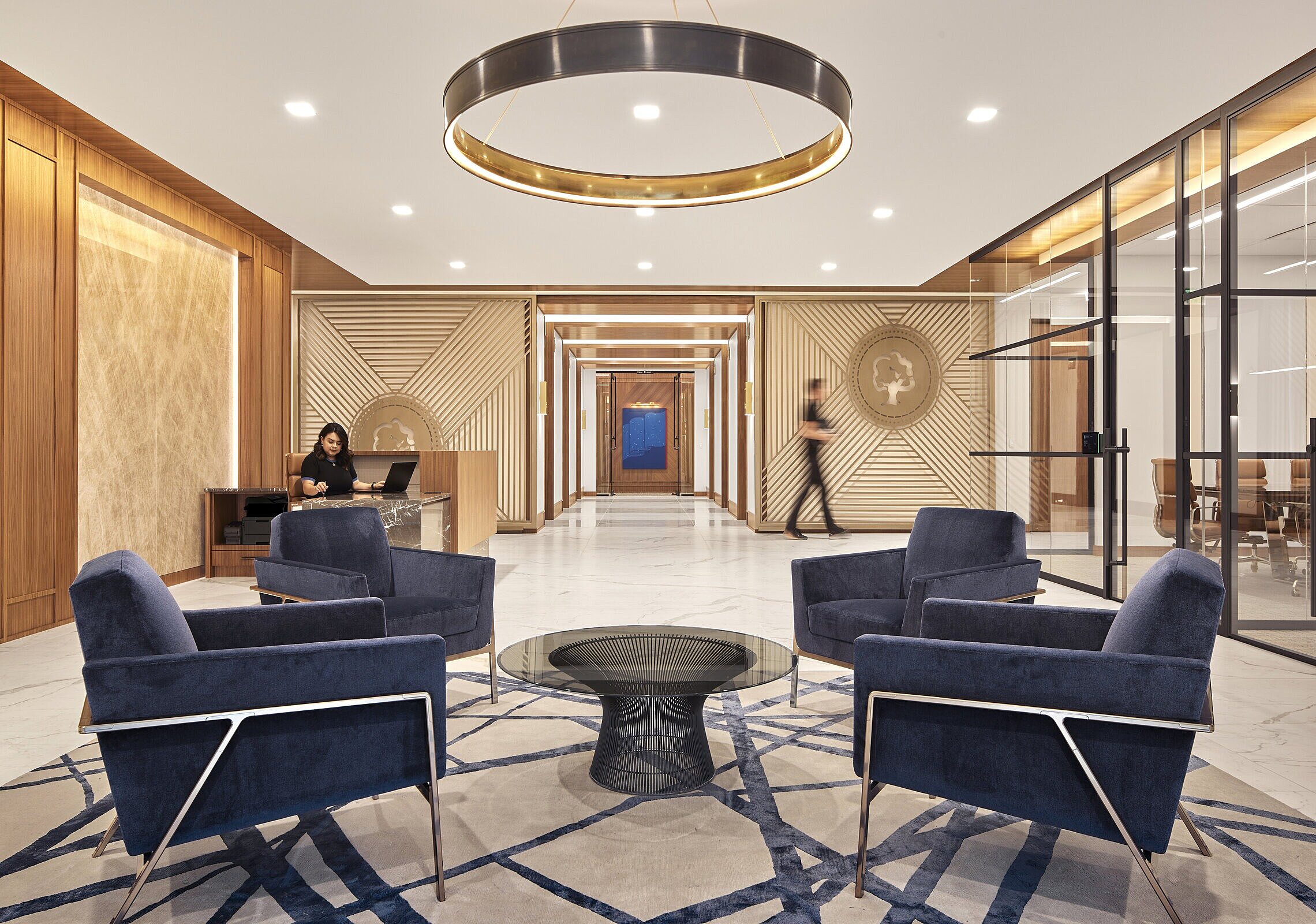 luxury automotive sales group lobby with 4 blue lounge chairs sitting around a circular platner coffee table