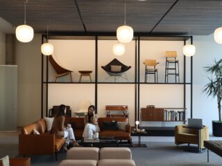 Coworkers sitting and chatting on a Muuto couch in the MillerKnoll Showroom in Dallas, TX