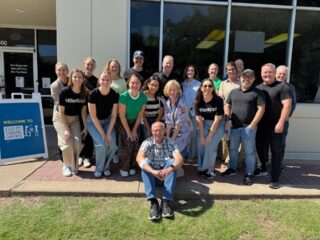 A company group smiling outside of Feed My Starving Children