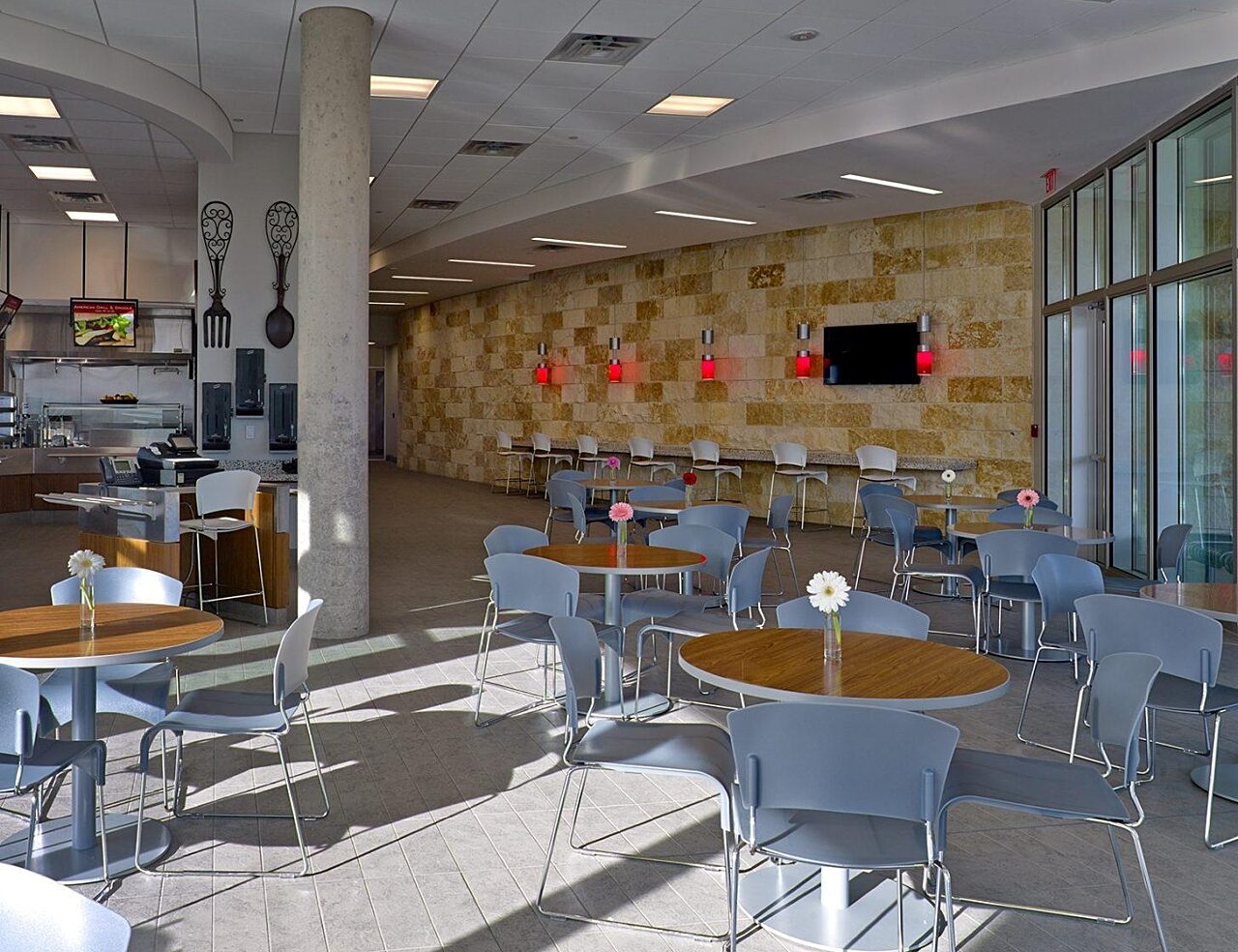 dining hall in corporate office with round wooden tables and grey chairs