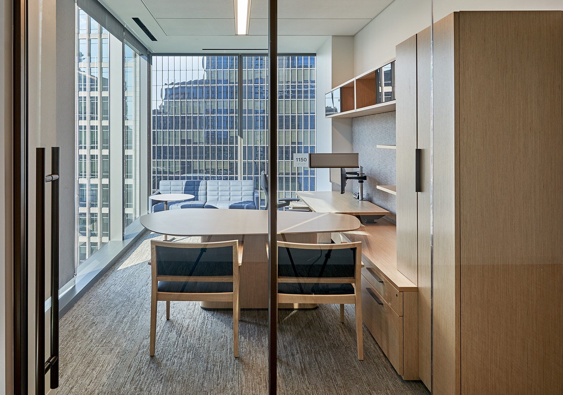 Katten Private office with storage, a desk, two blue chairs, and monitors