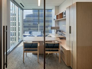 Katten Private office with storage, a desk, two blue chairs, and monitors