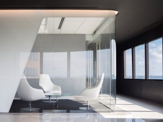 Corporate office small conference room with, chairs, and a coffee table all enclosed in glass walls