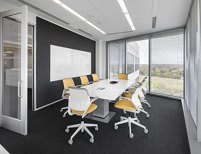 corporate office small conference room with a white table and yellow and white chairs