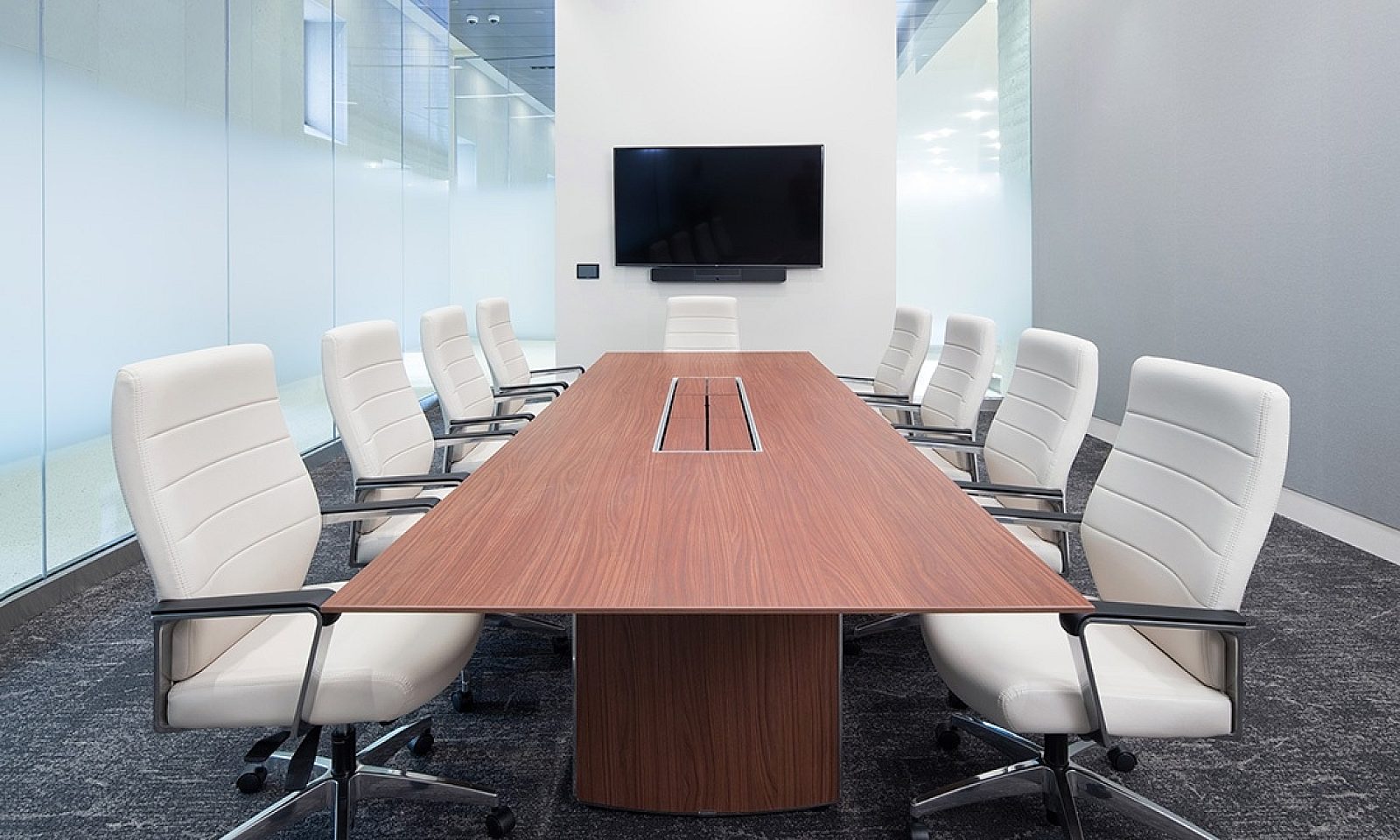 8 Global Furniture white high back chairs seated around a long wooden rectangular table in a small conference room